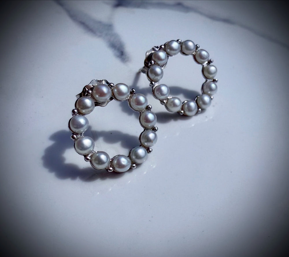 Sterling silver open circle pearl studs — worn on ear
