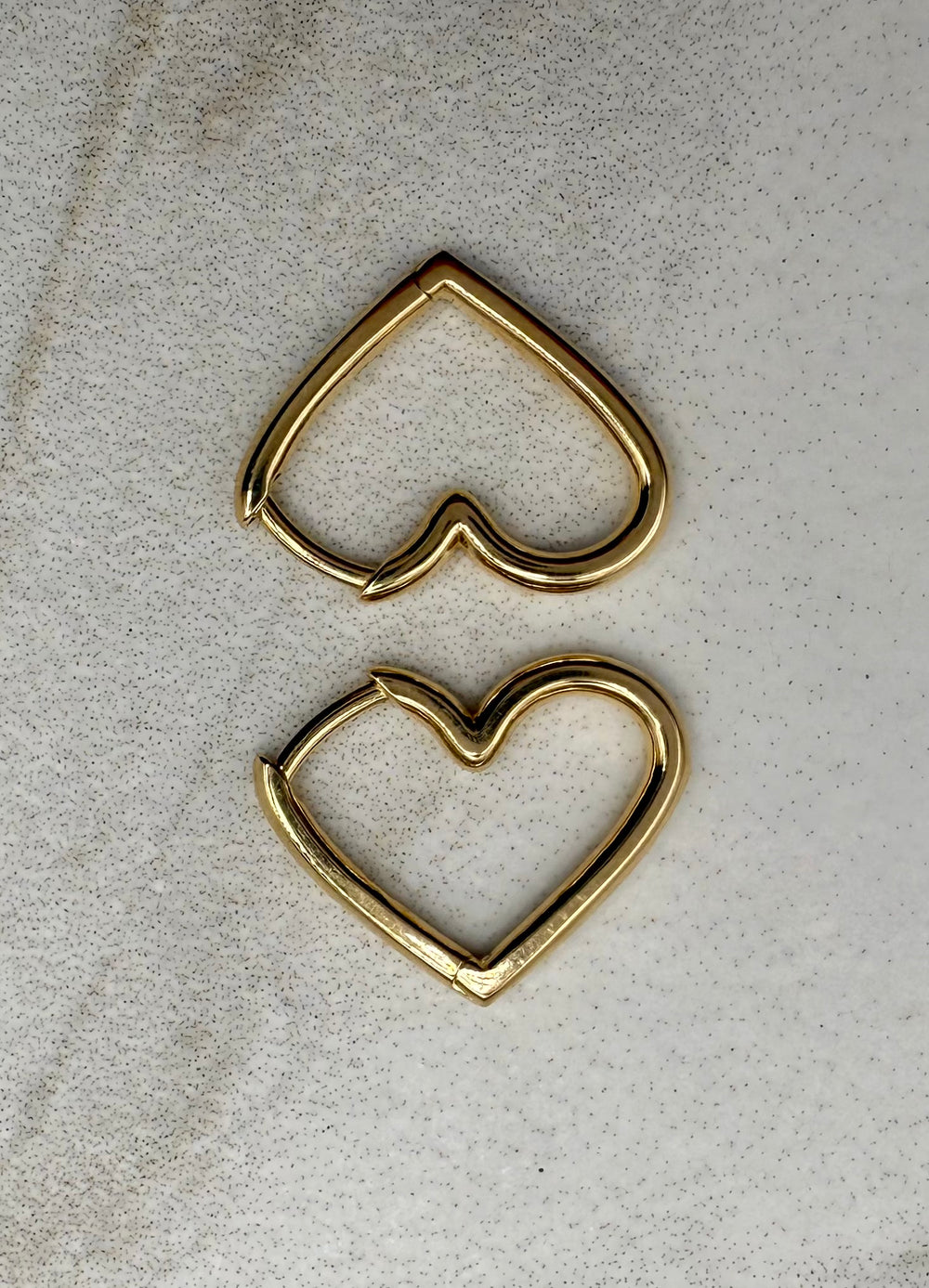 14k yellow gold heart huggie earrings — worn on ear