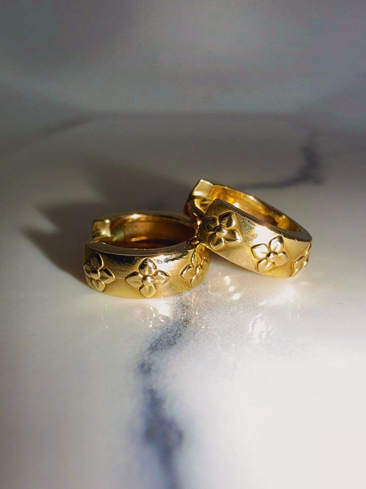 Gold Andalucia huggie earrings — worn on ear