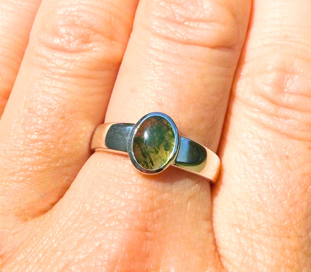 14k yellow gold low-profile moss agate ring — worn on hand